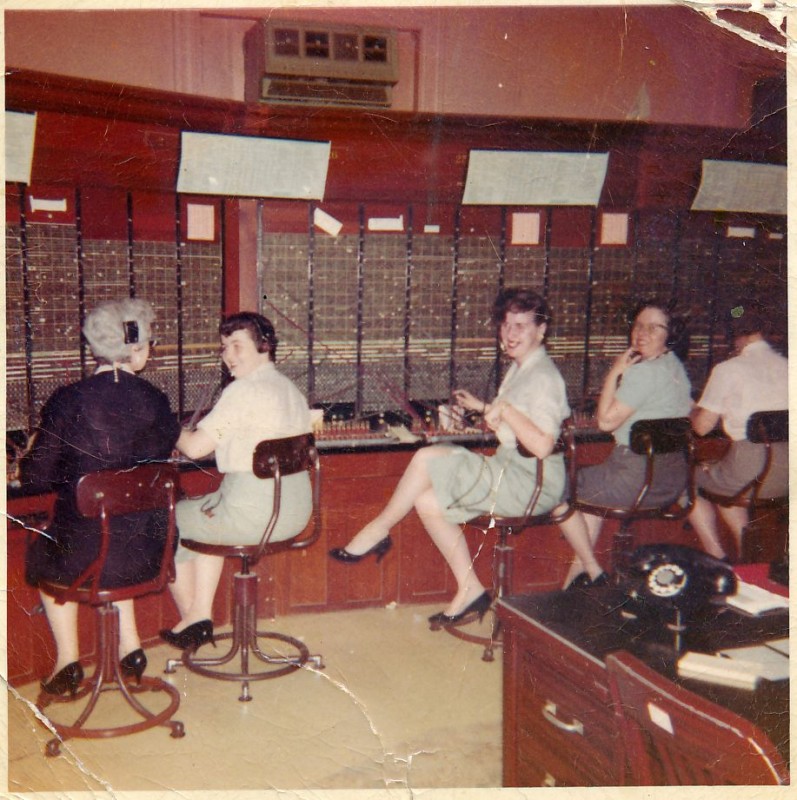 New England Tel. "Working on Harvard Street switchboard in Hyde Park. Pictured, from left to right: teacher Mary Miles, Mary Hannon, Mary Lou Leary, and unidentified woman. Contributor: Mary Lou Greene.