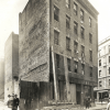 Black-and-white photo of the exterior of the 330 North Street building, with people standing and walking by in the foreground