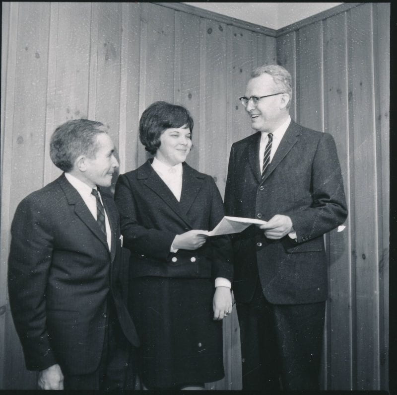 Black-and-white photo of Albert Fulchino and John W. Lederle standing with Audrey Taub 