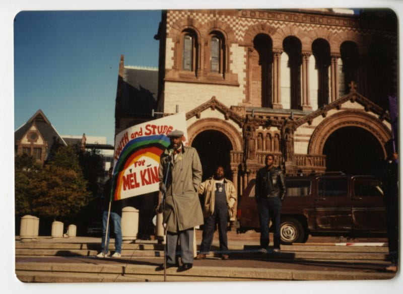 Color photograph shows King giving a speech in front the Trinity Church in Copley Square.