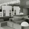 Black-and-white photo of couches, study cubicles, and lamps inside the Healey Library
