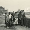 Black-and-white photo of 11 people posing for a group photo with the Calf Pasture Pumping Station building in the background