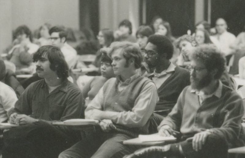 Students sitting in classroom desks listening to a lecture