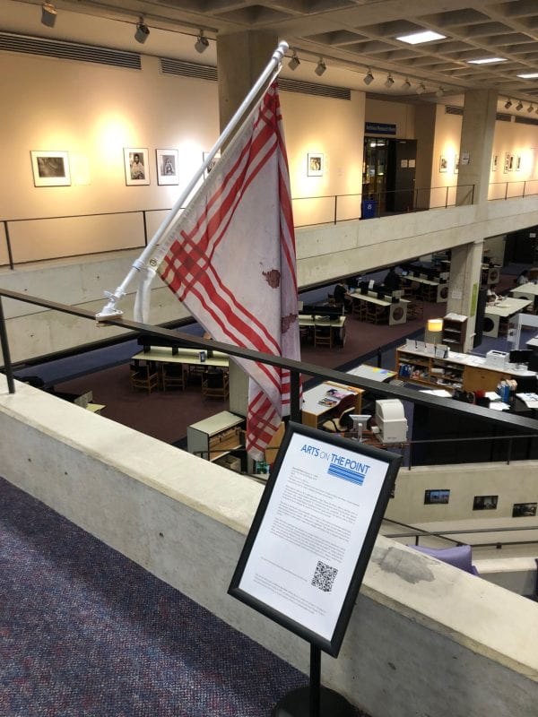 Photograph showing flag on a railing in a gallery