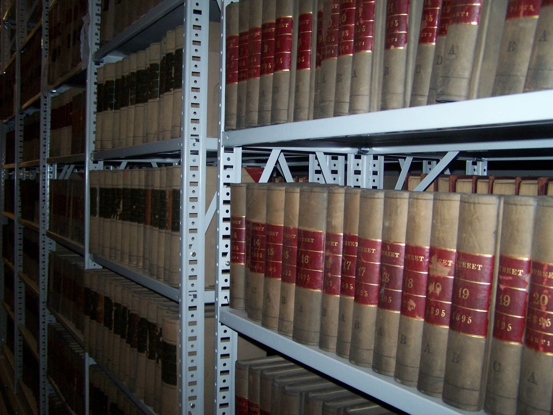 Shelves of bound volumes of records at the City Archives of Boston.