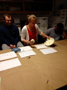 TA Carolyn Horlacher explains the various types of ceramics to students in the field school.