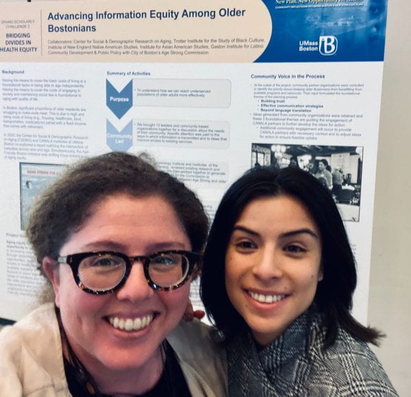 two women in front of a research poster