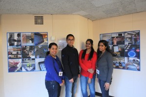 Ivis, Long, Likhita and Shilpa standing in front of the photo display