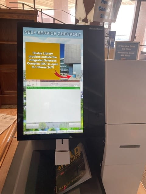 Image of the Healey Library self-checkout machine featuring a book being checked out and the confirmation screen 