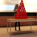 A blue team captain takes on Stack Attack challenge for a minute, although she able to only successfully to stack the cup into a pyramid shape.