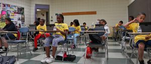 Students face the classroom in their fun yellow t-shirts! 