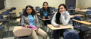 Group of three students pose in classroom desks!