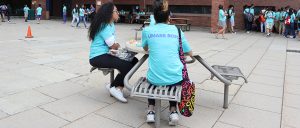 Two students sit at table outside by McCormack Hall for lunch. 