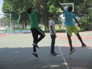 Three students playing basketball.
