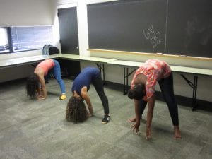 three girls bending down for exercise.