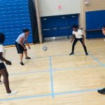 students pass the ball to each other in a game of four square