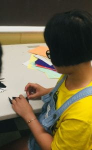 a student works diligently to perfect her orogami piece